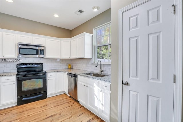 kitchen with sink, stainless steel appliances, light stone counters, white cabinets, and decorative backsplash