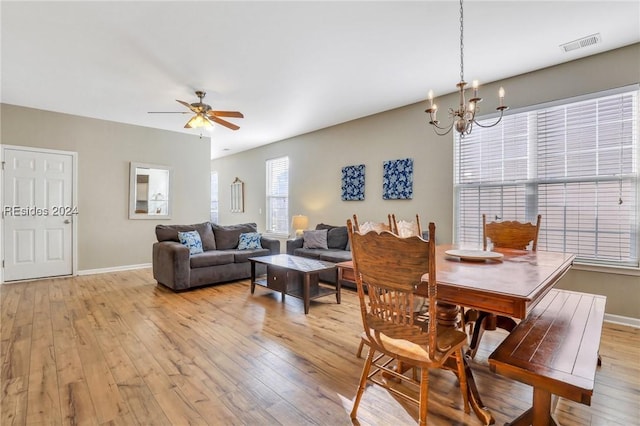 dining room with ceiling fan with notable chandelier and light wood-type flooring