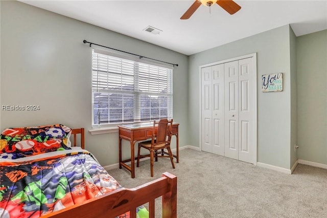 bedroom featuring light colored carpet, a closet, and ceiling fan