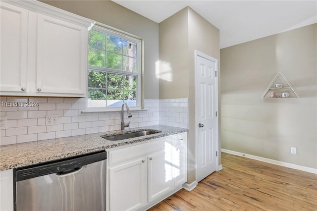 kitchen with dishwasher, sink, light stone countertops, and white cabinets