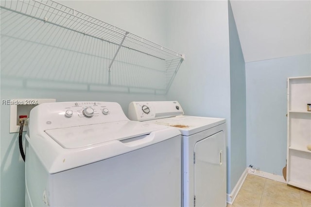 laundry room with washing machine and clothes dryer and light tile patterned floors