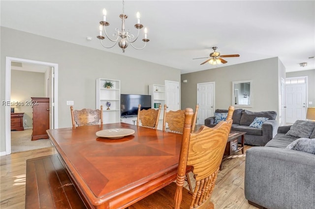 dining room with ceiling fan with notable chandelier and light hardwood / wood-style flooring