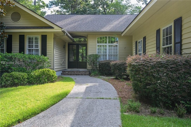 entrance to property with a yard and french doors