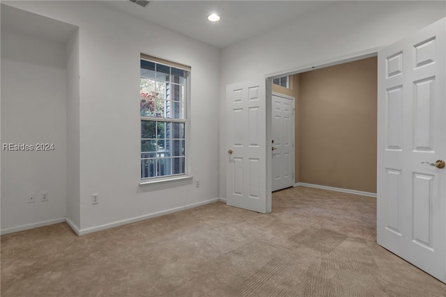 unfurnished room with light colored carpet