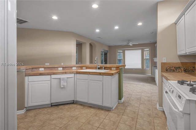 kitchen with sink, white appliances, wooden counters, white cabinets, and kitchen peninsula