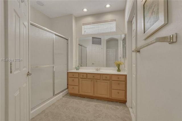 bathroom with vanity, an enclosed shower, and tile patterned flooring