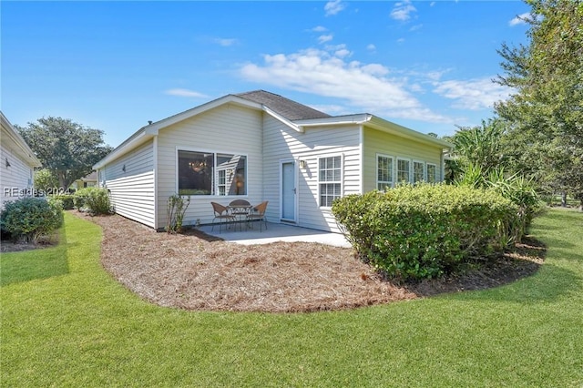 rear view of house featuring a patio and a yard