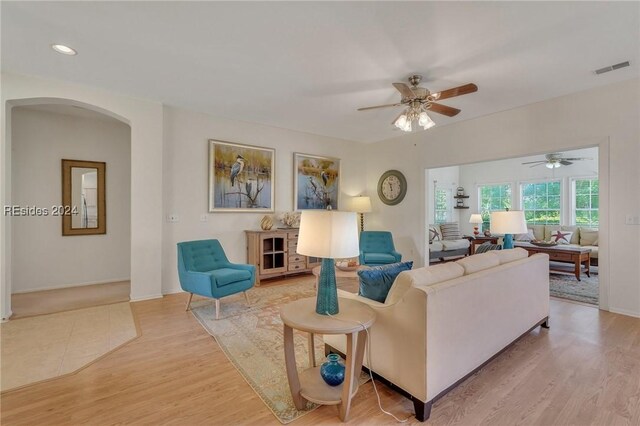 living room with light hardwood / wood-style flooring and ceiling fan