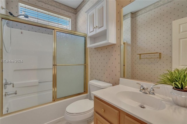 full bathroom featuring vanity, shower / bath combination with glass door, and toilet