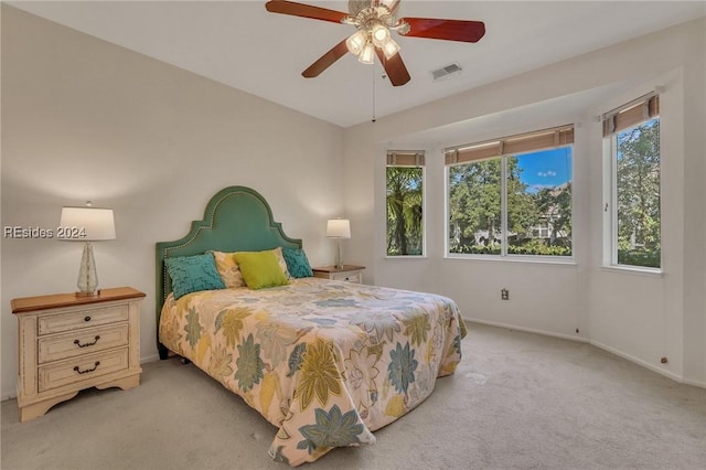 bedroom with multiple windows, light carpet, and ceiling fan