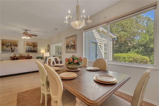 dining area with ceiling fan with notable chandelier and light wood-type flooring