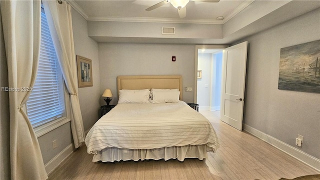 bedroom with hardwood / wood-style flooring, ceiling fan, and ornamental molding