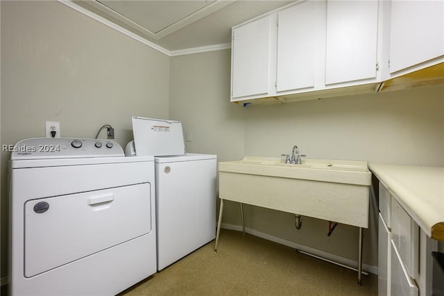 laundry area featuring crown molding, cabinets, and separate washer and dryer