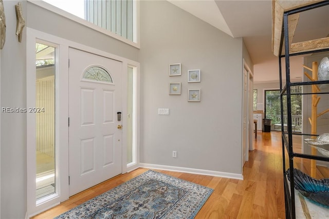 entrance foyer with lofted ceiling, a wealth of natural light, and light hardwood / wood-style floors