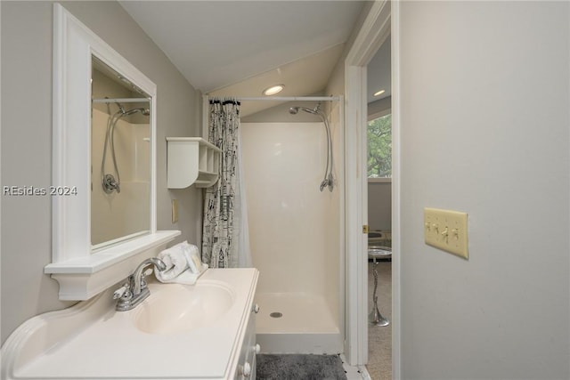 bathroom with a shower with curtain, vanity, and vaulted ceiling