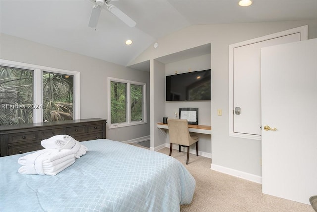 bedroom featuring ceiling fan, lofted ceiling, built in desk, and light carpet