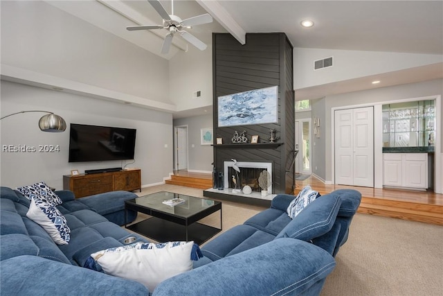 living room with high vaulted ceiling, beamed ceiling, carpet floors, a large fireplace, and ceiling fan