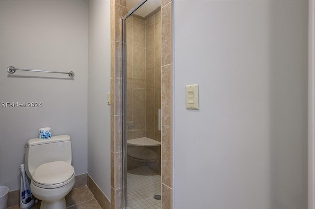 bathroom with a shower with shower door, tile patterned floors, and toilet