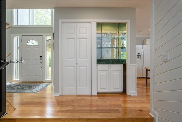 foyer featuring light hardwood / wood-style floors and wood walls