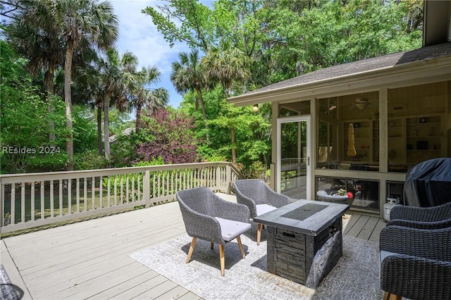 deck with area for grilling, a sunroom, and a fire pit