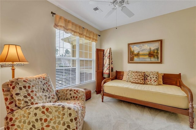 sitting room with ceiling fan and carpet flooring