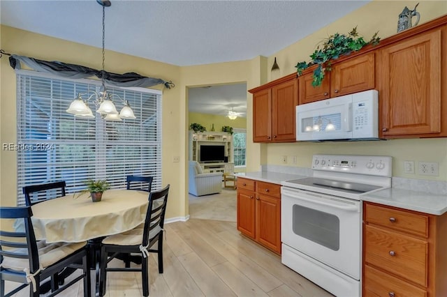 kitchen with pendant lighting, white appliances, light hardwood / wood-style floors, and a chandelier