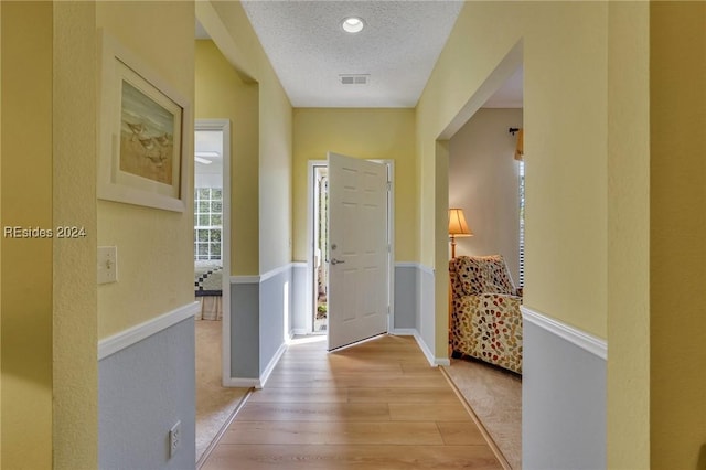 foyer entrance featuring a textured ceiling and light wood-type flooring