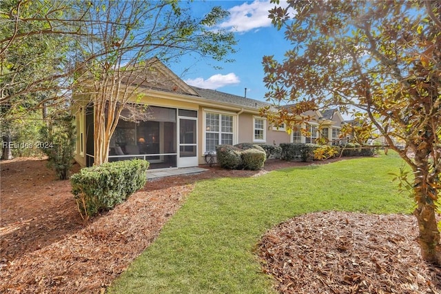 back of house featuring a yard and a sunroom