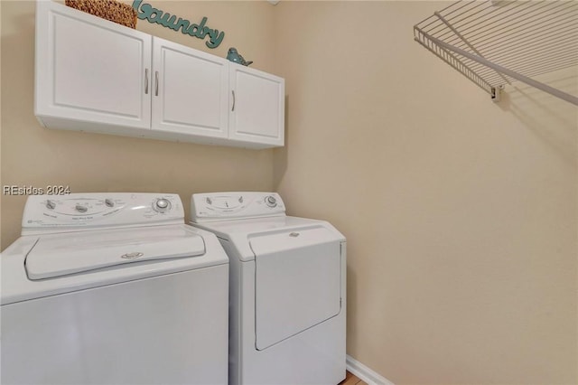 laundry room featuring washer and dryer and cabinets