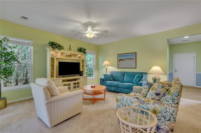 carpeted living room with a healthy amount of sunlight, a textured ceiling, and ceiling fan