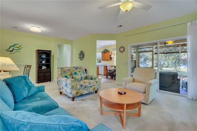 carpeted living room with ceiling fan and a textured ceiling