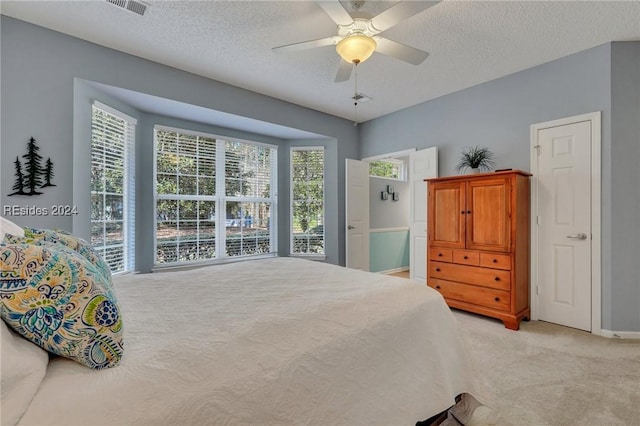 carpeted bedroom featuring a textured ceiling and ceiling fan