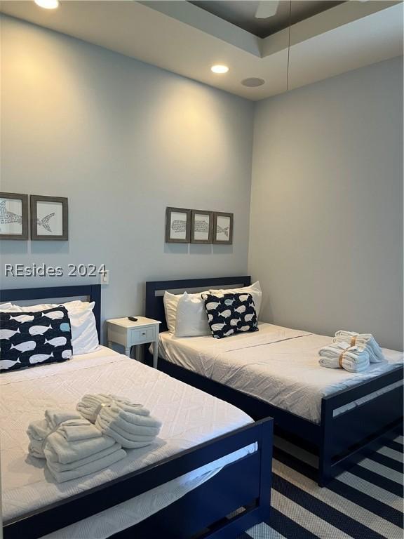 bedroom with ceiling fan and a tray ceiling