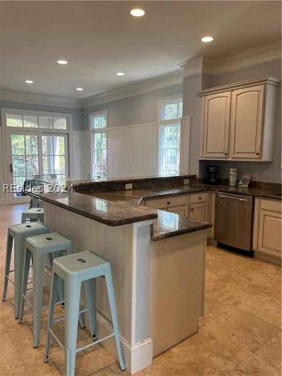 kitchen featuring a breakfast bar, dishwasher, dark stone countertops, kitchen peninsula, and crown molding