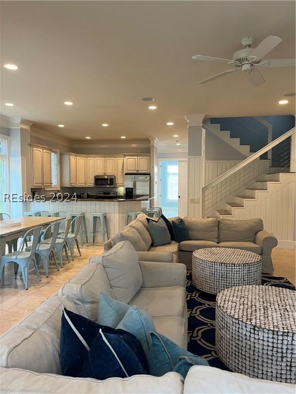 living room with crown molding and ceiling fan