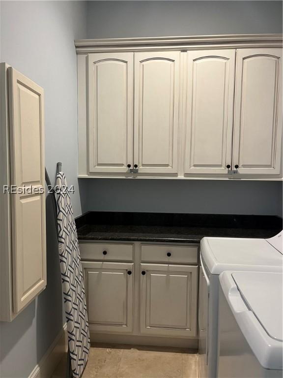 washroom featuring independent washer and dryer, cabinets, and light tile patterned flooring