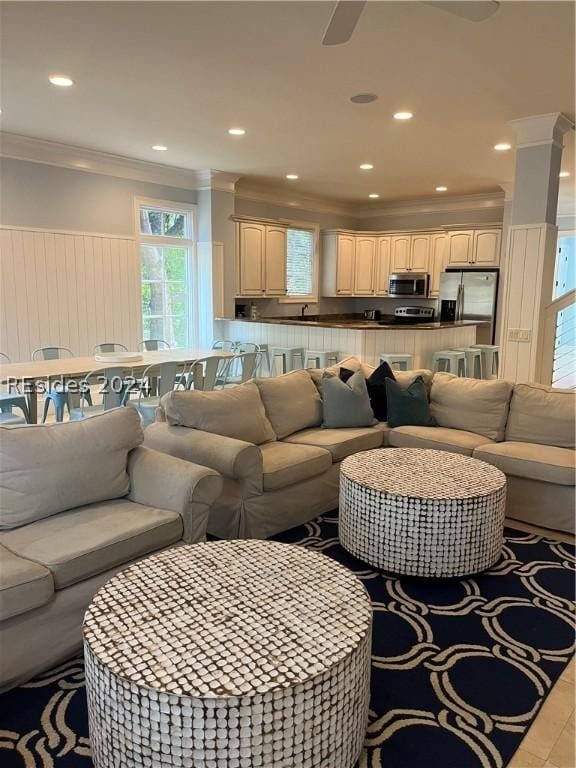 living room with crown molding and ceiling fan