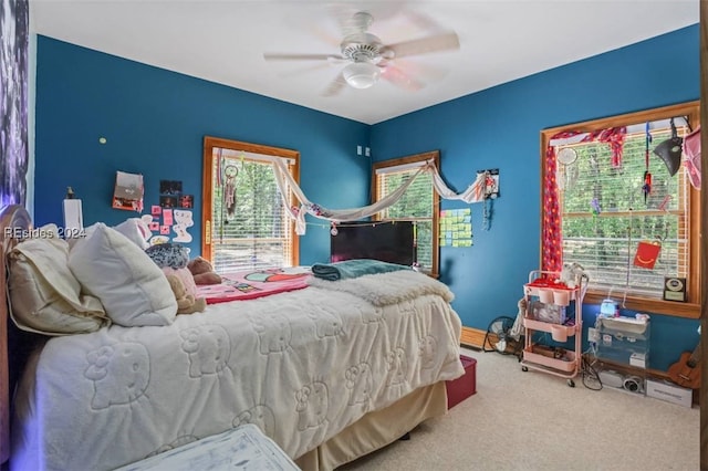 carpeted bedroom with ceiling fan and multiple windows