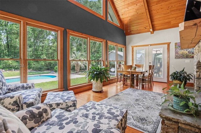 sunroom / solarium featuring vaulted ceiling with beams, wooden ceiling, and french doors