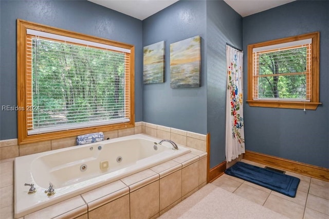 bathroom featuring plenty of natural light, tiled bath, and tile patterned flooring