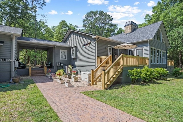 view of front of property featuring a wooden deck, a front yard, and a patio