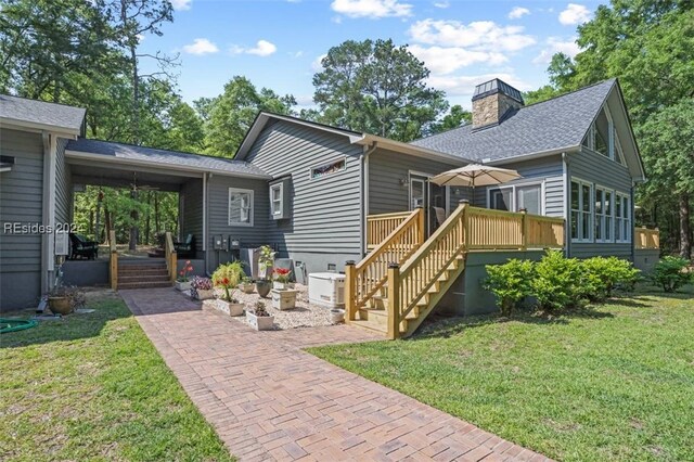 view of front facade with a deck, a patio area, and a front yard