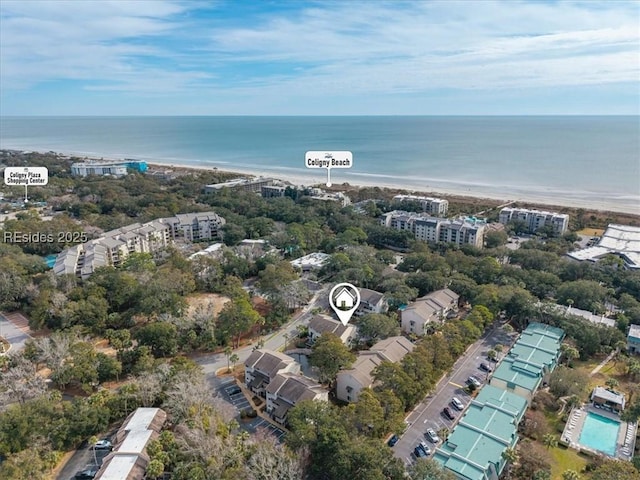 birds eye view of property with a water view and a beach view