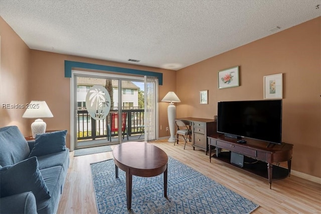 living room featuring light hardwood / wood-style floors and a textured ceiling