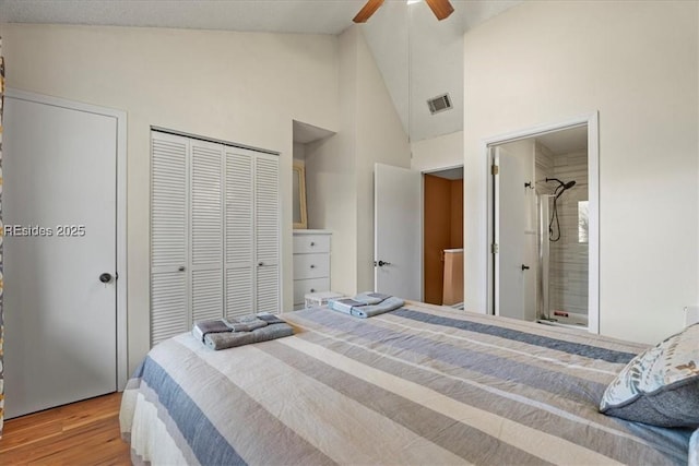 bedroom featuring ceiling fan, wood-type flooring, ensuite bathroom, and high vaulted ceiling