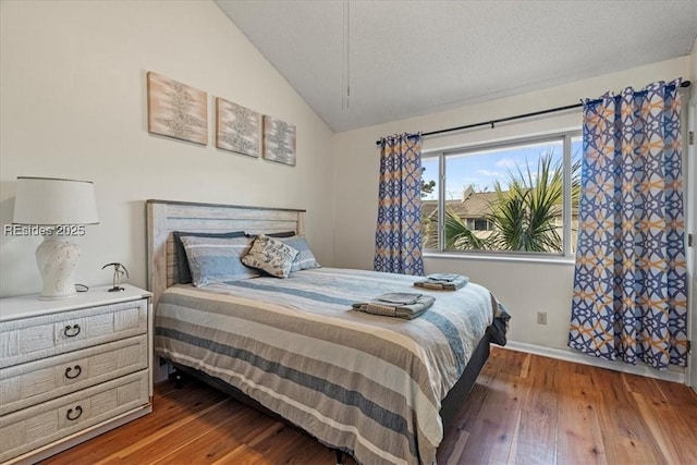 bedroom featuring wood-type flooring, vaulted ceiling, and a textured ceiling