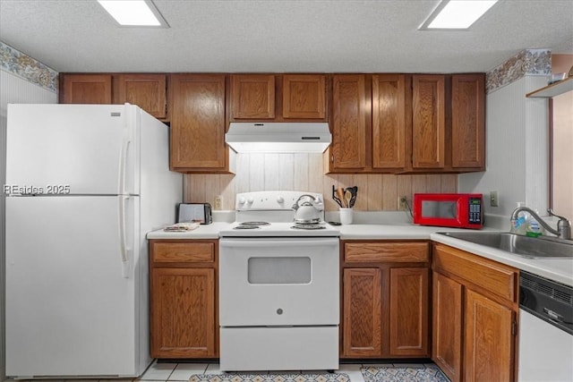 kitchen with sink, light tile patterned floors, a textured ceiling, and white appliances