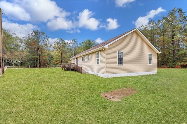 view of side of home featuring a wooden deck and a lawn