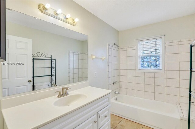 full bathroom featuring vanity, tile patterned floors, toilet, and tiled shower / bath