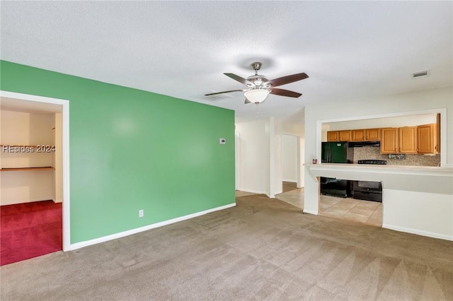 unfurnished living room featuring ceiling fan, light colored carpet, and a textured ceiling